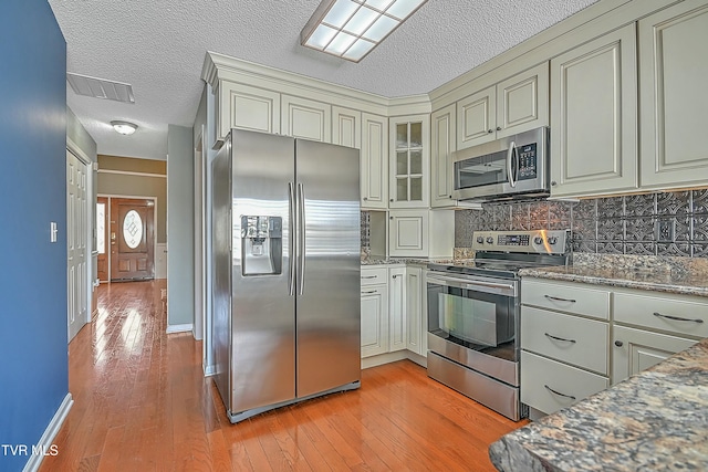 kitchen featuring decorative backsplash, light wood-style flooring, and appliances with stainless steel finishes