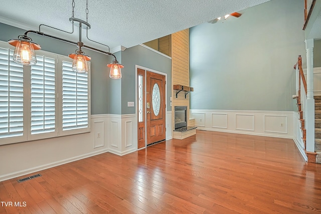 entryway featuring a wealth of natural light, visible vents, a textured ceiling, and hardwood / wood-style flooring