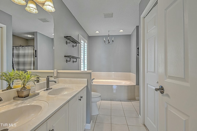 bathroom featuring tile patterned floors, a garden tub, visible vents, and a sink