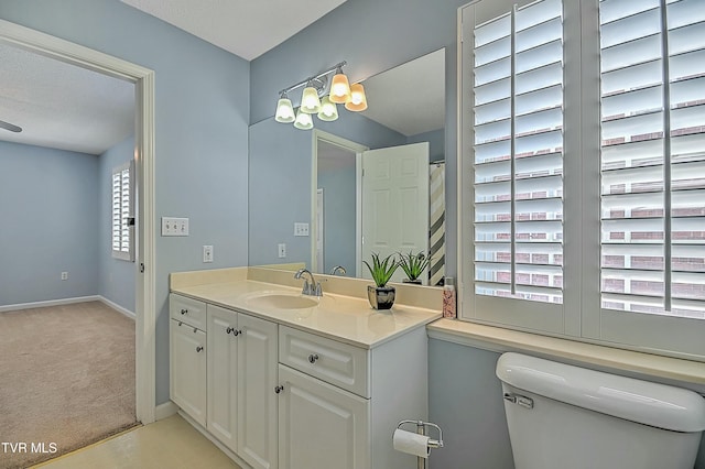 bathroom featuring baseboards, toilet, and vanity