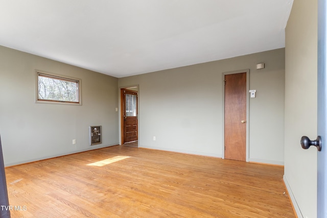 spare room with light wood-type flooring and baseboards