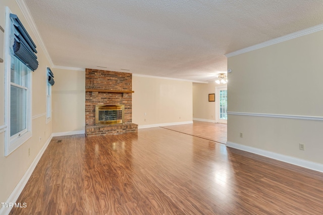 631 Bowmantown Rd, Telford, TN 37690 - unfurnished living room with a textured ceiling, wood finished floors, a brick fireplace, ornamental molding, and baseboards
