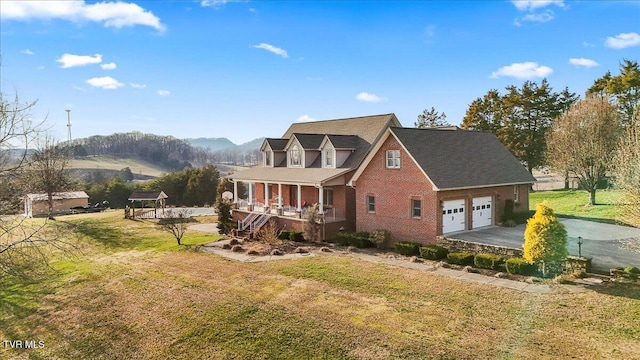 exterior space featuring a porch, driveway, brick siding, and a front yard