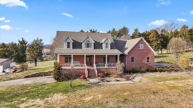 view of front of home with stairs, brick siding, a porch, and a front lawn