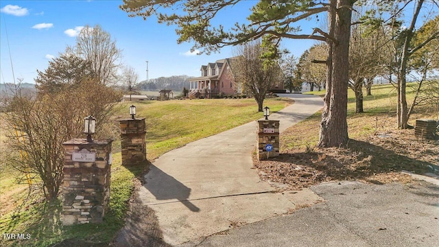 view of property's community featuring driveway and a yard