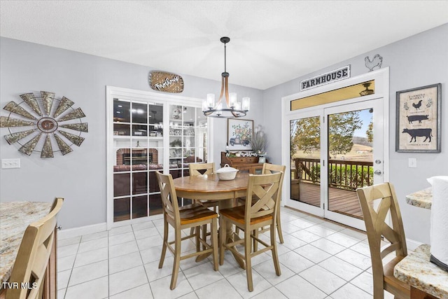 dining area with a chandelier, baseboards, and light tile patterned flooring