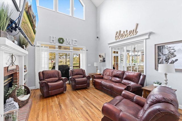 living area featuring a high ceiling, wood finished floors, and a fireplace