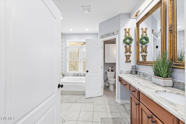 bathroom featuring double vanity, a textured ceiling, a garden tub, toilet, and tile patterned floors