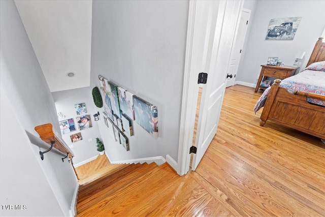 staircase featuring wood finished floors and baseboards