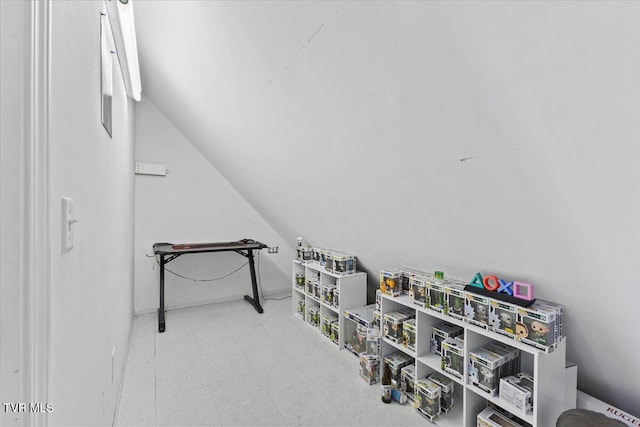 recreation room featuring tile patterned floors and vaulted ceiling