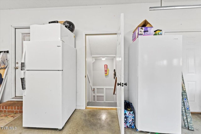 kitchen with finished concrete floors and freestanding refrigerator