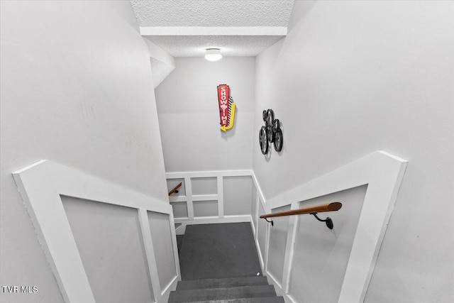 staircase with a textured ceiling