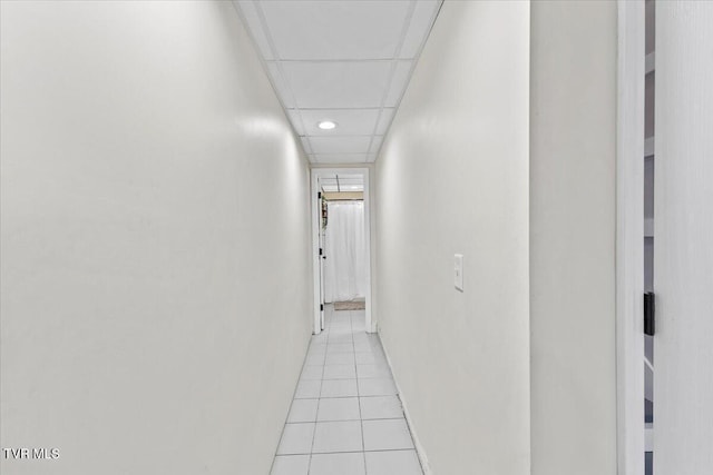 corridor with light tile patterned floors and a drop ceiling