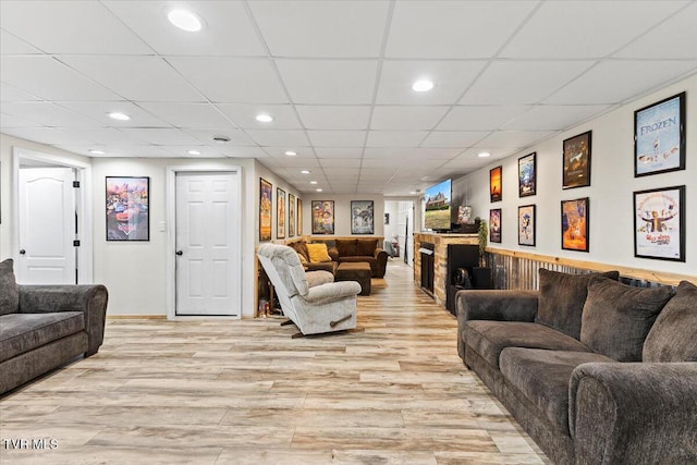 living room featuring recessed lighting, light wood-type flooring, and a paneled ceiling