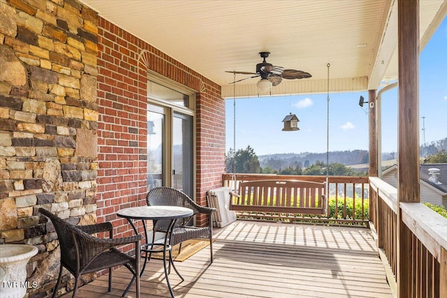 wooden deck featuring a porch and a ceiling fan