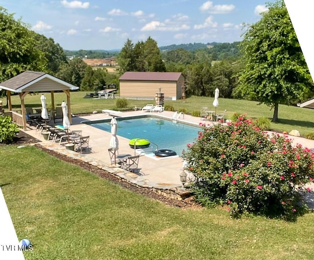 pool featuring an outbuilding, a diving board, a gazebo, a patio area, and a lawn