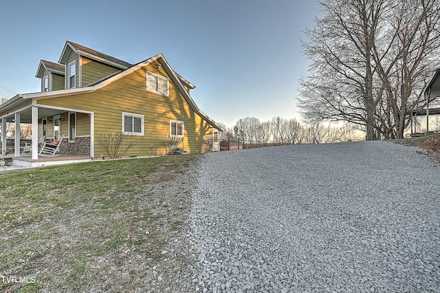 view of side of home featuring covered porch