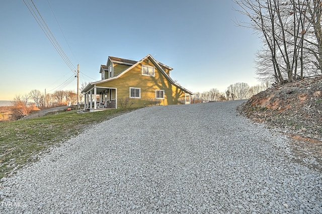 exterior space with gravel driveway and covered porch