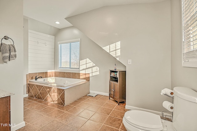 full bathroom featuring a garden tub, toilet, tile patterned floors, and vaulted ceiling