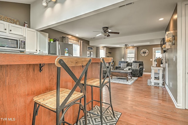 kitchen with baseboards, visible vents, ceiling fan, white cabinets, and appliances with stainless steel finishes