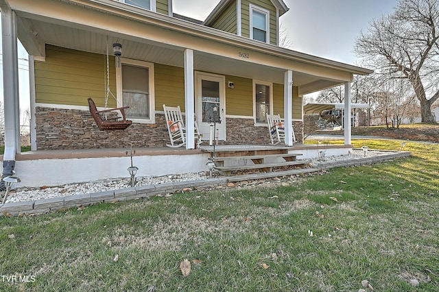 doorway to property featuring stone siding, a porch, and a yard