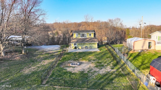 exterior space featuring a fire pit, an outbuilding, a front yard, and fence