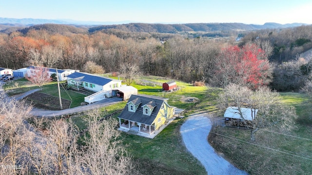 birds eye view of property with a mountain view and a wooded view