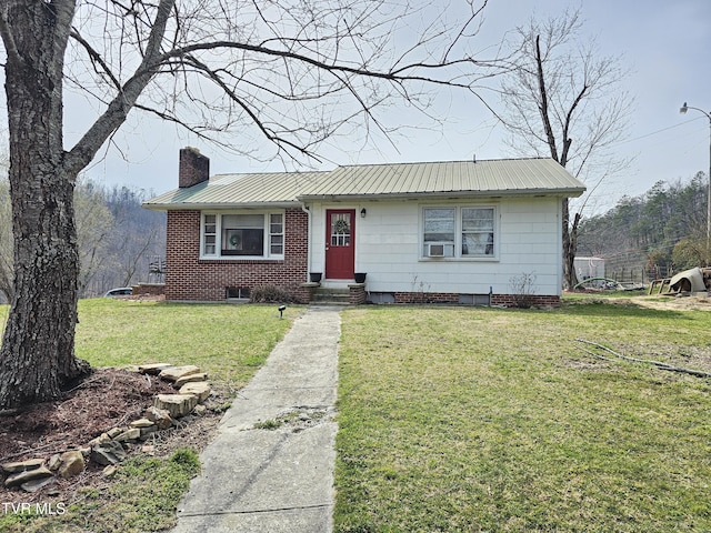 view of front of house featuring a front lawn, entry steps, cooling unit, a chimney, and metal roof