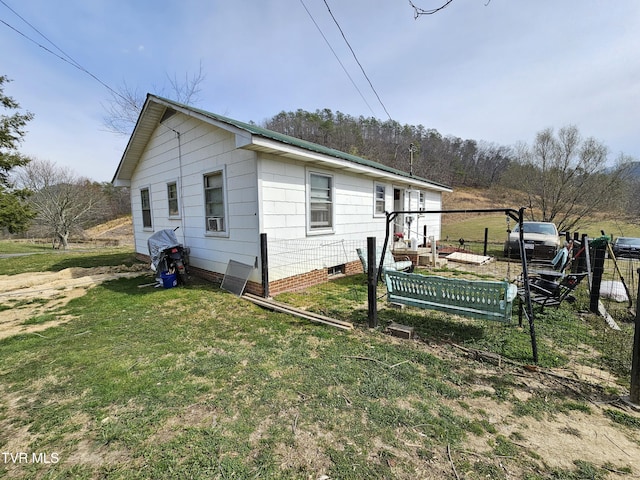 view of side of property with crawl space and a yard