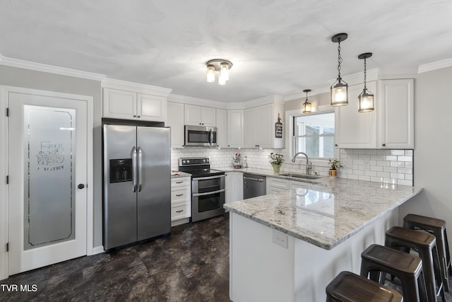 kitchen with ornamental molding, appliances with stainless steel finishes, a peninsula, white cabinets, and a sink