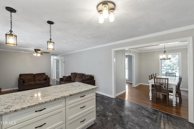 kitchen featuring hanging light fixtures, ceiling fan with notable chandelier, white cabinets, and baseboards