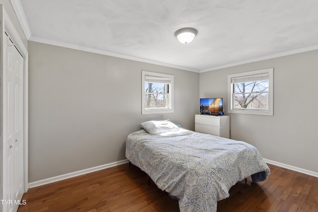 bedroom with wood finished floors, baseboards, and a closet