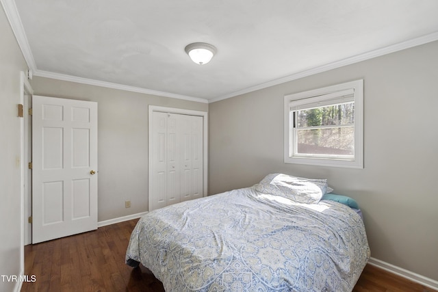 bedroom with wood finished floors, baseboards, a closet, and ornamental molding