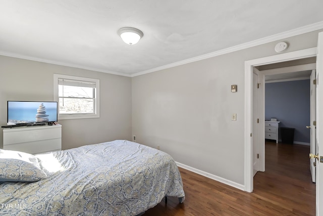 bedroom featuring crown molding, baseboards, and wood finished floors