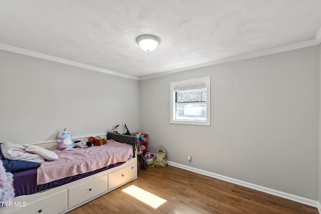 bedroom featuring baseboards, wood finished floors, and ornamental molding