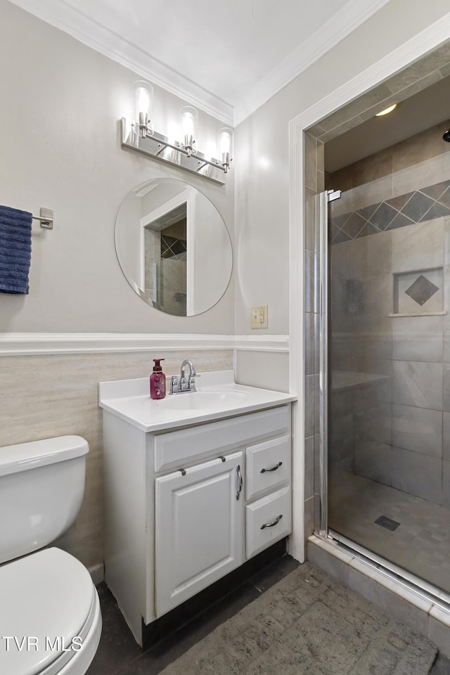 bathroom featuring vanity, a shower stall, a wainscoted wall, and ornamental molding