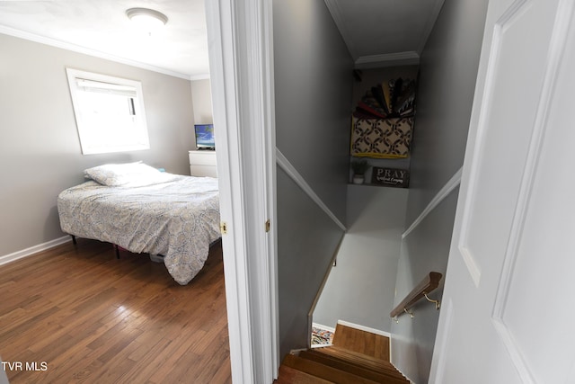 bedroom featuring hardwood / wood-style flooring, crown molding, and baseboards