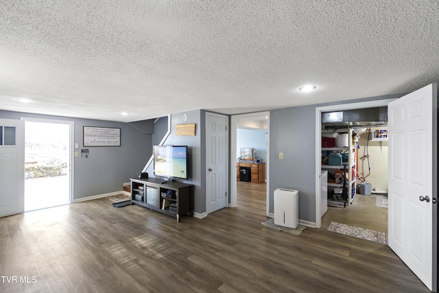 living room with wood finished floors, baseboards, and a textured ceiling