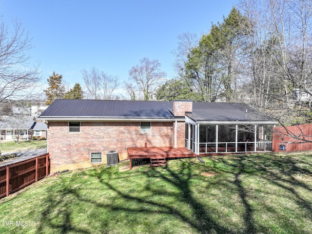 rear view of house featuring cooling unit, brick siding, a sunroom, and metal roof