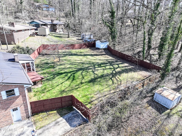 view of yard featuring fence, an outdoor structure, and a shed