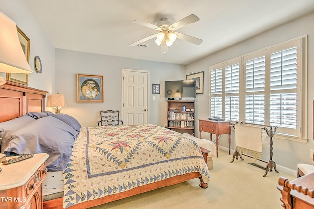 carpeted bedroom with visible vents, baseboards, and a ceiling fan