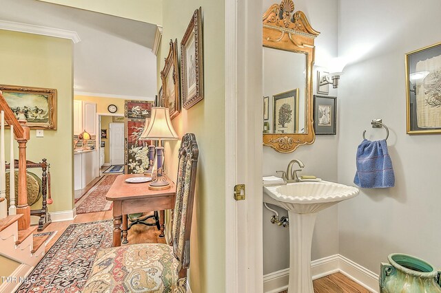 bathroom featuring crown molding, baseboards, and wood finished floors