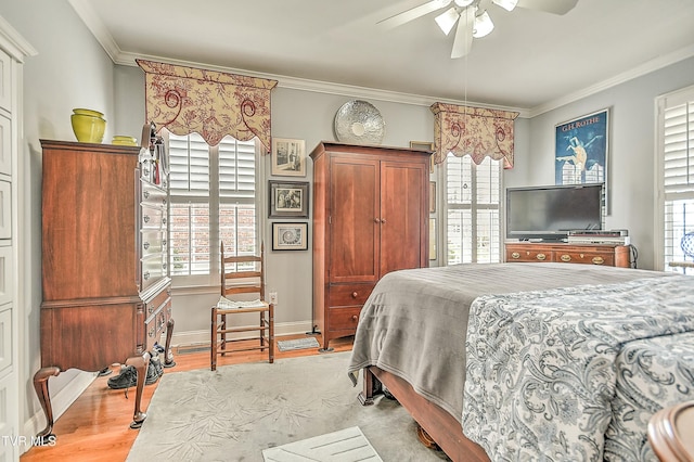 bedroom with light wood-type flooring, multiple windows, and ornamental molding