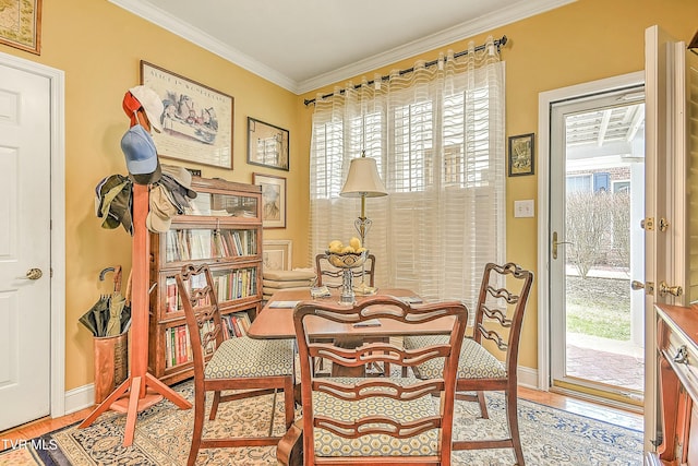 interior space with light wood-style flooring, baseboards, and ornamental molding