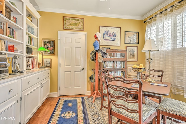 office space featuring baseboards, light wood-style flooring, and crown molding