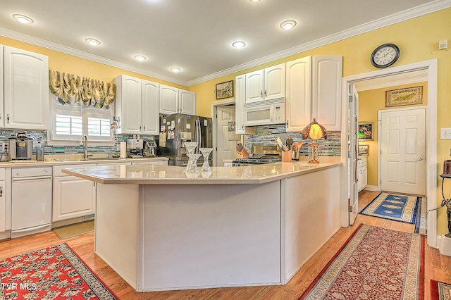 kitchen with white cabinetry, stainless steel appliances, light wood-style floors, and ornamental molding