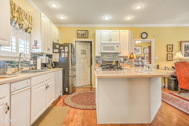 kitchen featuring a sink, white cabinetry, appliances with stainless steel finishes, crown molding, and light wood finished floors