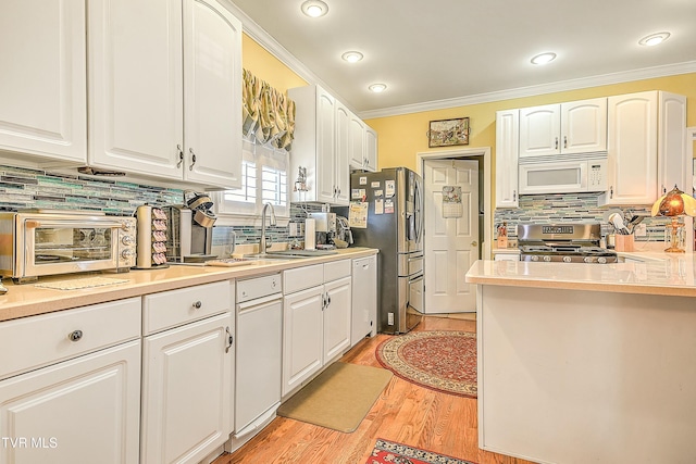 kitchen featuring a sink, appliances with stainless steel finishes, and white cabinets