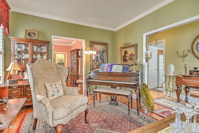 living area with ornamental molding, baseboards, and wood finished floors