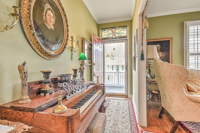 entryway featuring crown molding, wood finished floors, and a healthy amount of sunlight